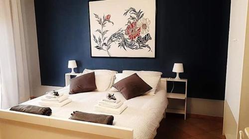 圣埃拉莫因科莱The holiday house的卧室配有一张白色床,墙上挂有绘画作品