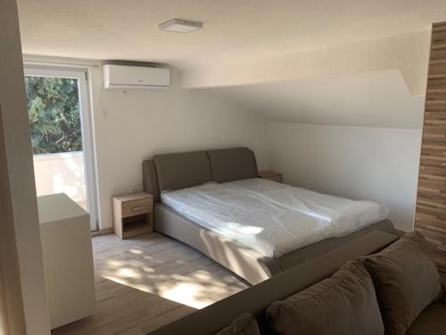 沃迪切Apartmani Dobra Villa的一间卧室配有一张床、一张沙发和一个窗口