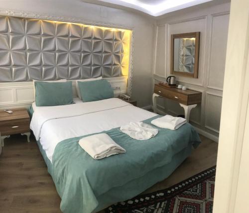 伯萨汉柯大酒店的一间卧室配有一张大床和毛巾