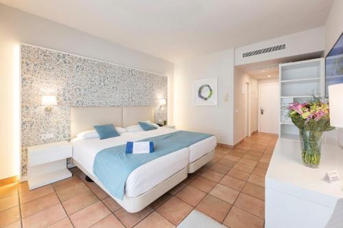 奇克拉纳－德拉弗龙特拉Aldiana Club Andalusien的一间卧室配有一张大床和花瓶