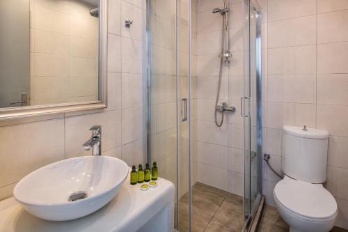 费拉Olive Tree Suites的浴室配有盥洗盆、淋浴和卫生间
