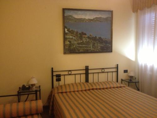 威尼斯艺术家旅馆的卧室配有一张床,墙上挂有绘画作品