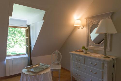 埃屈埃莫维尔la ferme chevalier的一间卧室配有带镜子和椅子的梳妆台