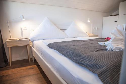 蒂蒂湖-新城Apartment JoniFee am Titisee的卧室配有一张带白色床单和枕头的大床。