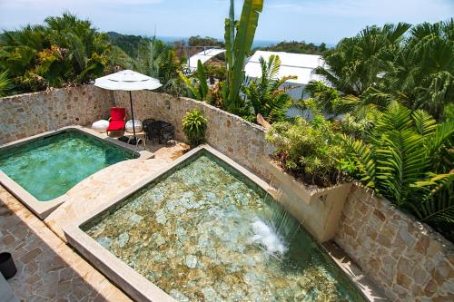 曼努埃尔安东尼奥盖亚保护区酒店 - 仅限成人的一座带遮阳伞的游泳池位于度假酒店旁
