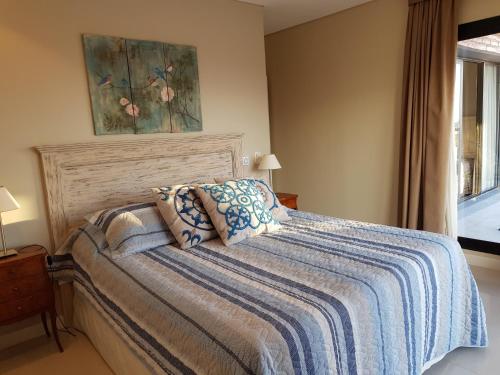 耶尔瓦布埃纳Elegante departamento 2D的一间卧室配有一张带蓝色毯子的床和窗户。