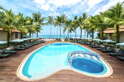 蔻立考拉克海湾度假酒店的游泳池位于带椅子和棕榈树的甲板上