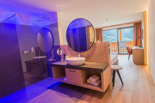 卡斯泰尔贝洛Panorama Hotel Himmelreich的一间带水槽和镜子的浴室