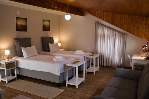 斯瓦科普蒙德Kramersdorf Guesthouse的一间卧室配有床、两张桌子和一张沙发