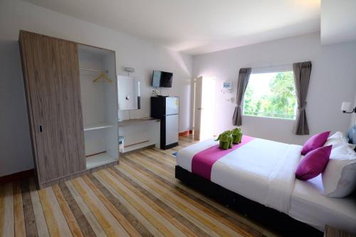丽贝岛Plaloma Resort Lipe的一间卧室配有一张带紫色枕头的大床