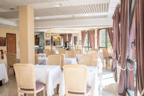 布雷西尔加拉贝尔酒店的一间设有白色桌椅的用餐室