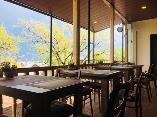 泰拉维Guest House Chiko的餐厅设有桌椅和大窗户。