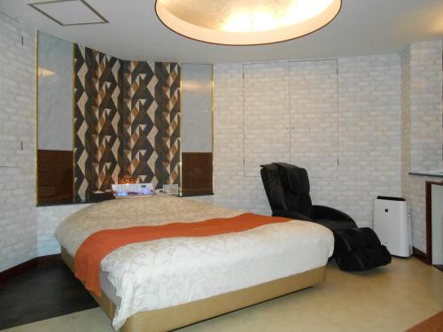 柏市Hotel Regina的一间卧室配有一张大床和一张黑椅