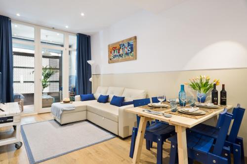 锡切斯Sans Souci Quality Apartments的客厅配有沙发和带蓝色椅子的桌子