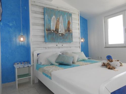 杜基拉特Sunrise Vid的卧室配有白色的床和蓝色的墙壁