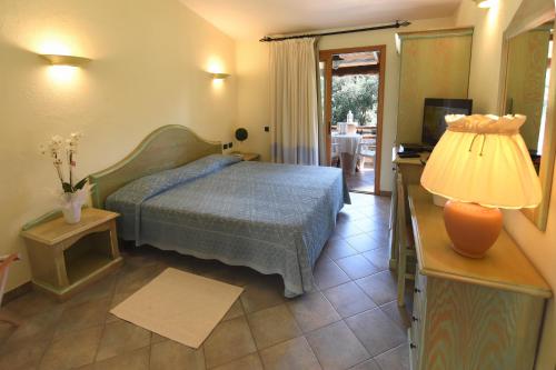 维拉西米乌斯苏吉甘缇酒店的一间卧室配有一张床和一张带台灯的桌子