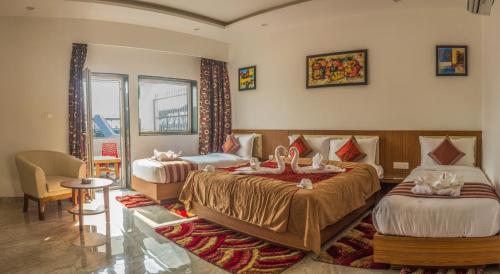 西里古里Hotel Suktara International的一间酒店客房,房间内设有两张床