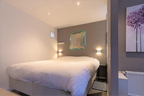 阿姆斯特丹Bed & Bike Studio Amsterdam的卧室配有白色的床和墙上的绘画作品