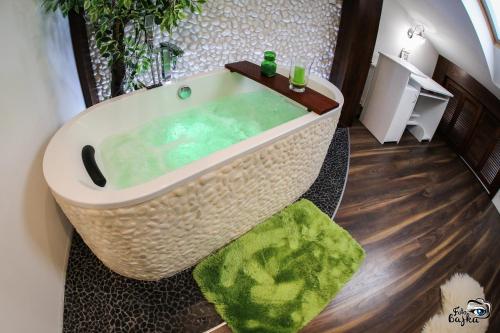 奥古斯图Elegancki loft w centrum.的浴室配有带绿色地毯的大浴缸