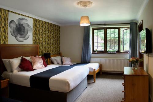 克劳利Little Foxes Hotel & Gatwick Airport Parking的酒店客房设有两张床和窗户。