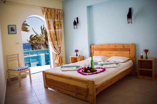 达哈布达哈布艾尔普里莫酒店的一间卧室,配有一张床,上面放着一碗水果
