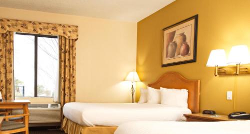 汤姆斯通Tombstone Grand Hotel, a Baymont by Wyndham的酒店客房设有两张床和窗户。