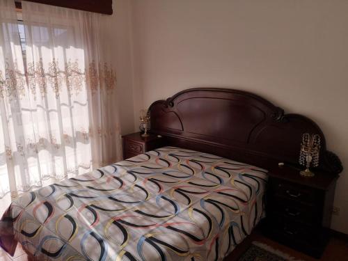 Vila ChãBlue Tex的一间卧室配有一张带木制床头板的床和窗户。