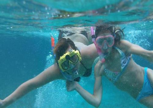 伯利兹城Shaka Caye All inclusive Resort的两个女孩子在水里,戴着眼镜