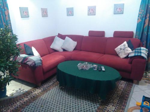 达森多夫Ferienwohnung Hops的客厅里一张红色的沙发,配有桌子