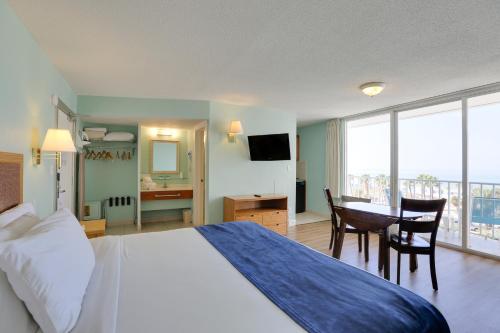 克利尔沃特The Beachview Inn Clearwater Beach的配有一张床、一张桌子和一张桌子的酒店客房