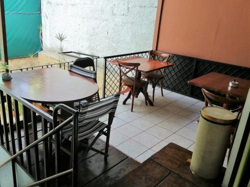圣何塞Casa Leon Guesthouse的餐厅阳台上的两张桌子和椅子