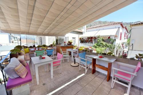 伊兹拉马斯托里斯旅馆的屋顶上设有五颜六色的桌椅的庭院