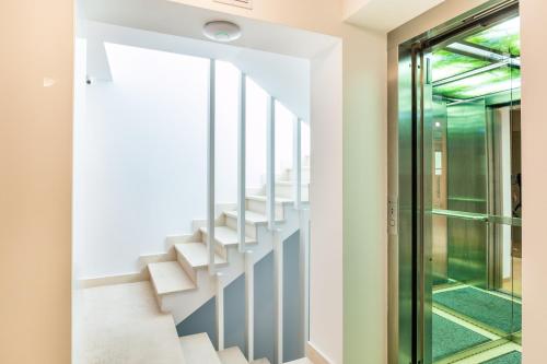布加勒斯特Venis Boutique Hotel的玻璃门房子的楼梯