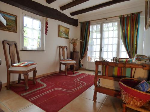 萨尔Maison d'hôtes de charme ttakoinenborda的客厅配有两把椅子和红色地毯
