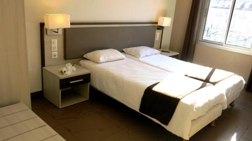 卢尔德朝圣者公寓式酒店的酒店客房设有一张大床和一个床头柜。