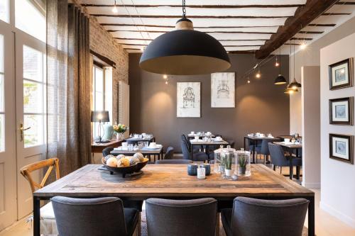 波马尔Hôtel Le Clos du Colombier 1817 Vignes & Spa的用餐室配有大型木桌和椅子