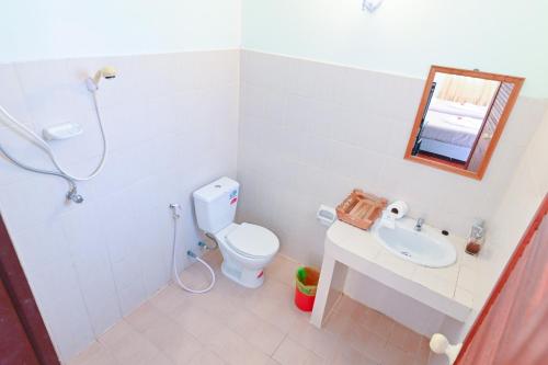 蔻立格拉屯度假村的一间带卫生间、水槽和镜子的浴室