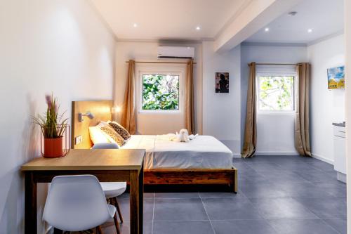 克拉伦代克Art Hotel的一间卧室配有一张床、一张书桌和两个窗户。