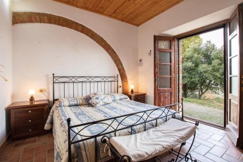 卡斯蒂戈隆·多尔希亚Agriturismo Il Poderuccio的一间卧室设有一张床和一个大窗户