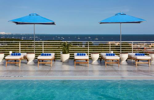 迈阿密Mr. C Miami - Coconut Grove的屋顶游泳池,配有躺椅和遮阳伞