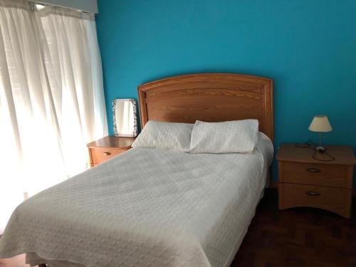 布兰卡港Encantador departamento en el centro de la ciudad的一间卧室设有一张蓝色墙壁的大床