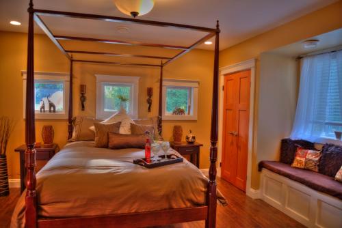 Shawnigan Lake莎尼甘住宿加早餐旅馆的一间卧室配有四柱床和沙发
