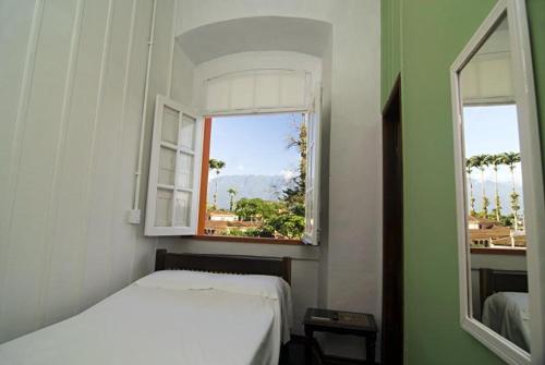 莫雷蒂斯Nhundiaquara Hotel e Restaurante的卧室配有白色的床和窗户。