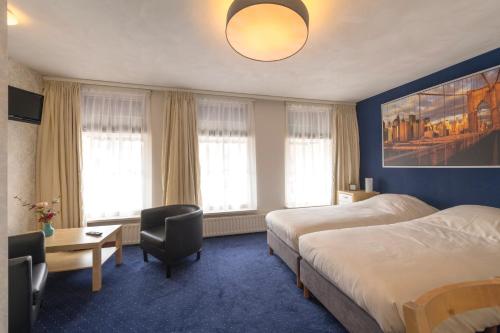 玛库姆德瓦赫的酒店客房配有两张床和一张桌子及椅子