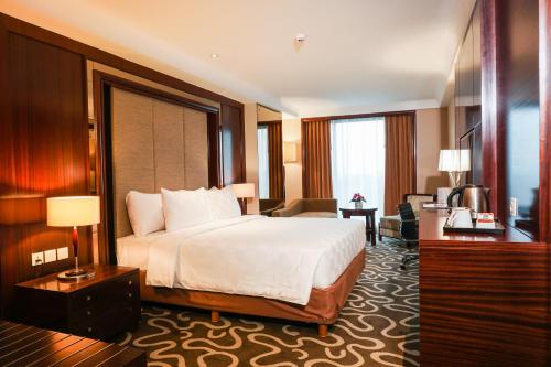 塞尔蓬Swiss-Belhotel Serpong的酒店客房设有床和客厅。