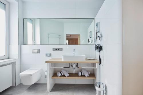 吕德斯海姆Hotel Rose的白色的浴室设有水槽和卫生间。
