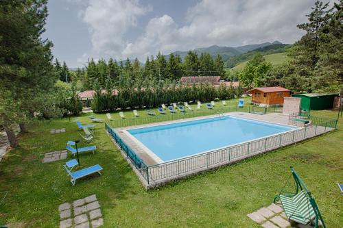 佩斯卡塞罗利艾瑞斯酒店的一个带椅子的庭院和房子的游泳池