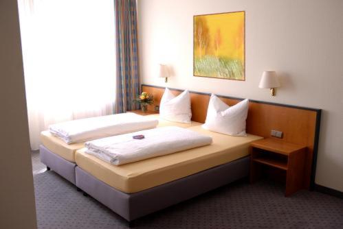 盖特海因莱比锡兰德酒店的酒店的客房 - 带2张带白色枕头的床