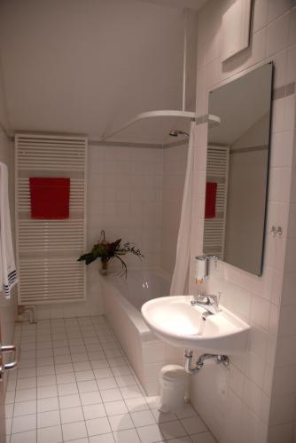盖特海因莱比锡兰德酒店的白色的浴室设有水槽、浴缸和水槽。