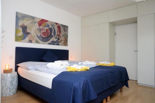 沃尔特湖畔佩莎赫希码头公寓的一间卧室配有蓝色的床和毛巾